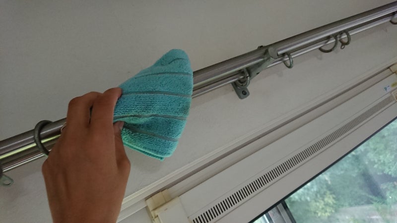 カーテンレールを雑巾で拭いてる画像